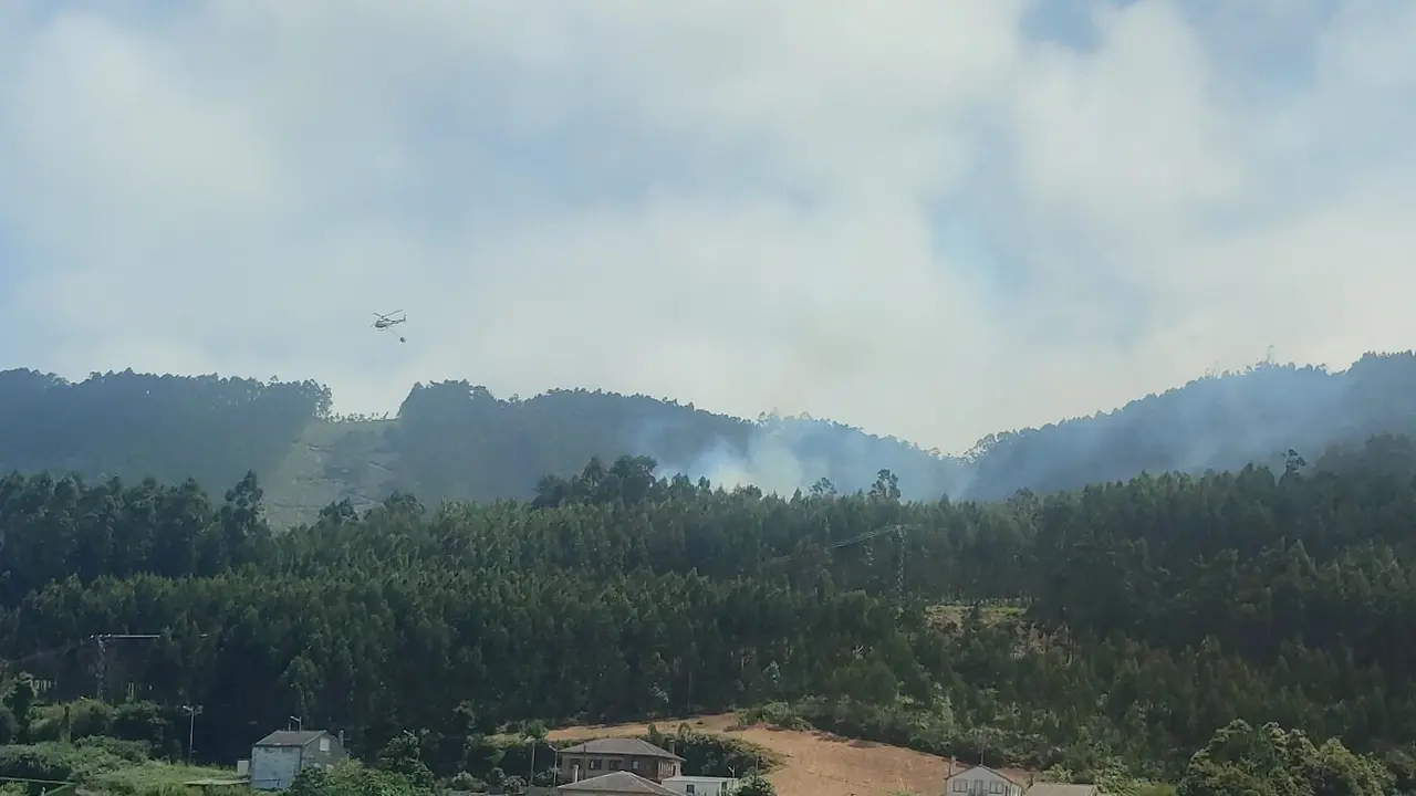 Un helicóptero durante las labores de extinción del incendio de O Vicedo. MARTÍN