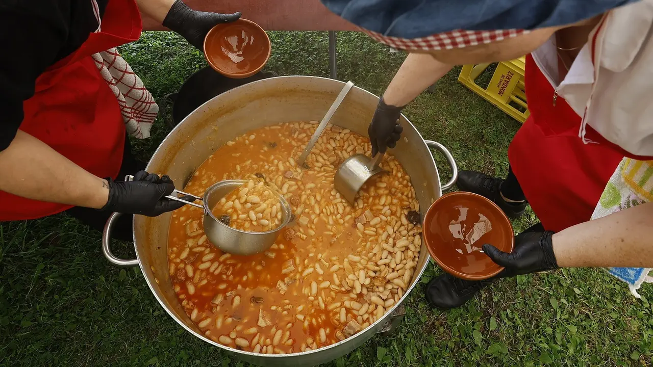 Dos cocineras sirven raciones durante la Festa da Faba. JM ÁLVEZ