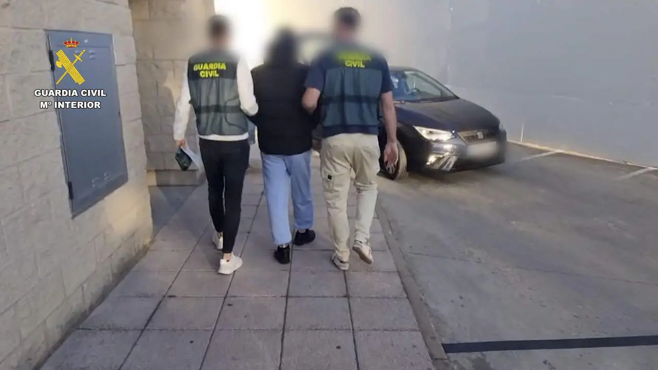 Dos agentes con uno de los detenidos por los robos en viviendas. GUARDIA CIVIL