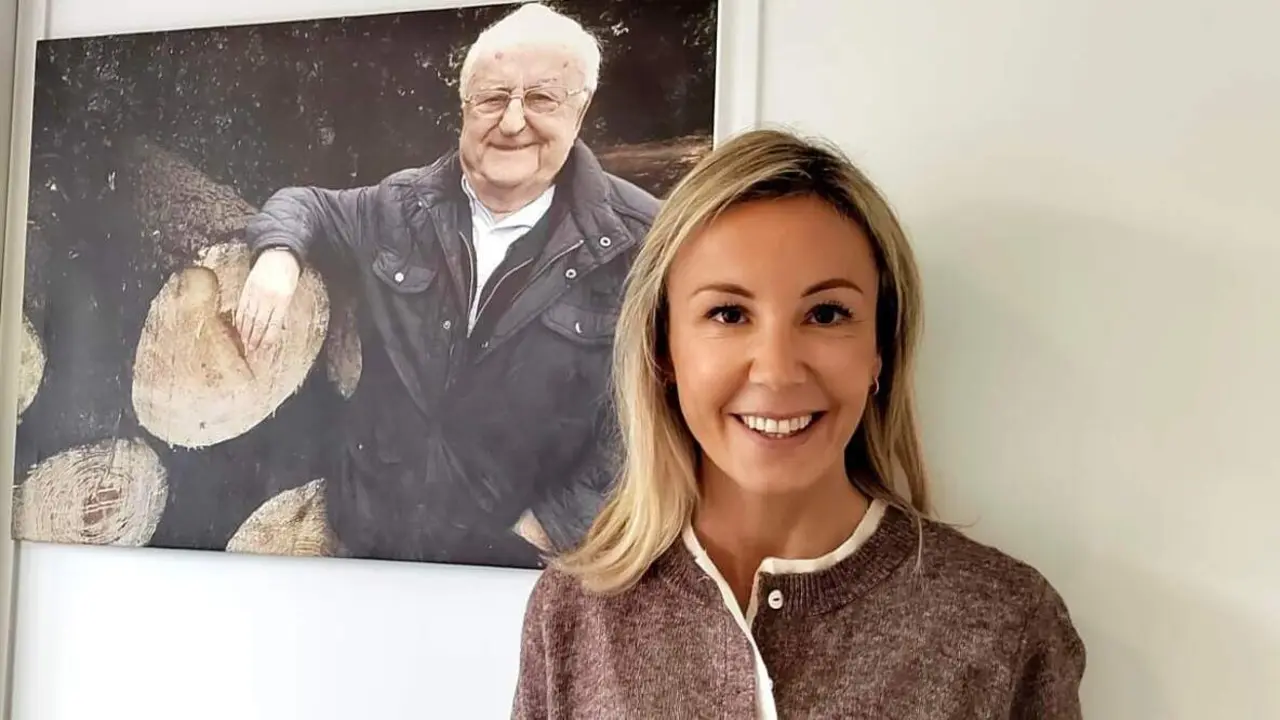 Sara Montero López, xerente de Maderas Edelmiro López de Trabada, coa foto do seu avó e fundador da empresa detrás.