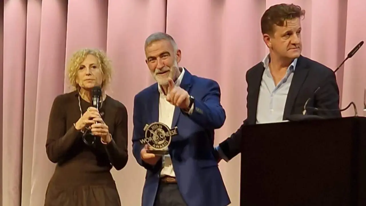 Ricardo Gómez, en el centro, con el galardón en la mano. EP