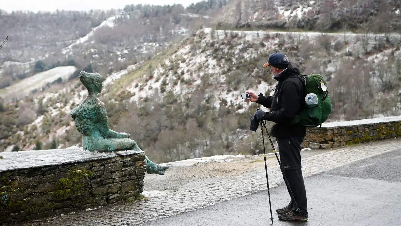 Un peregrino fotografía la nieve en Piedrafita. CARLOS CASTRO